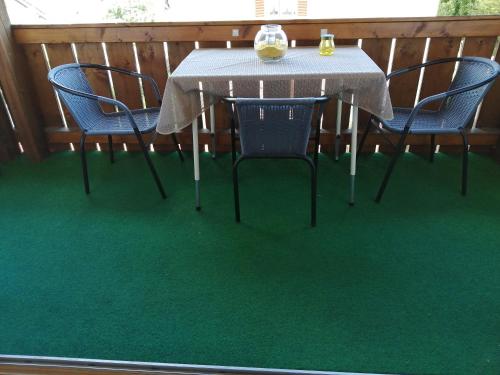 a table and chairs on a deck with green carpet at Schöne Wohnung in Deggendorf für 1 bis 5 Personen in Deggendorf