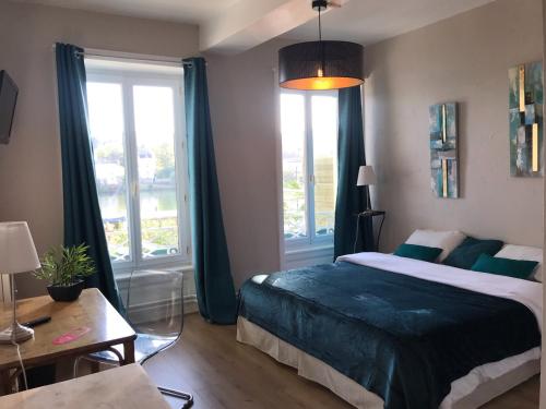 une chambre avec un lit et une grande fenêtre dans l'établissement Ô Petit Nice, à Neuville-sur-Saône