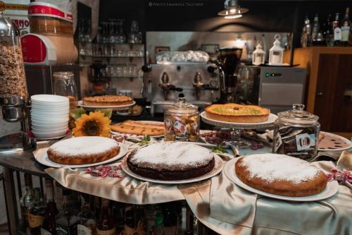 a table topped with cakes and pies on plates at Residence San Pietro Barisano in Matera