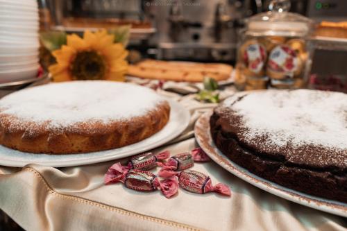two cakes sitting on plates on a table at Residence San Pietro Barisano in Matera