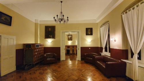 a living room with a couch and a chandelier at Gutshof Kämmerich - Fewo "Siebenschläferhöhle" in Altkalen