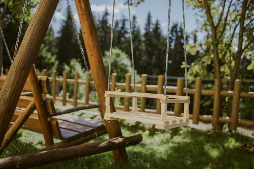 a swing in a yard with a wooden fence at Pension Tofalvi in Harghita-Băi