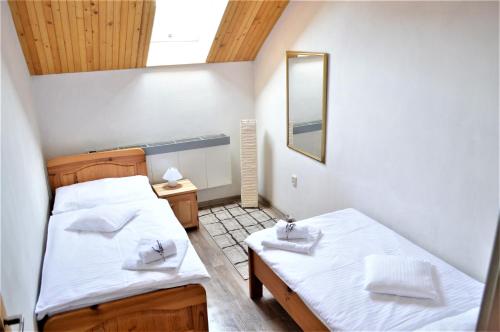 a small room with two beds and a mirror at Apartmány LÍVIA Litmanová in Litmanová