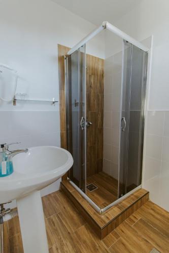 a bathroom with a shower and a white sink at Pension Tofalvi in Harghita-Băi