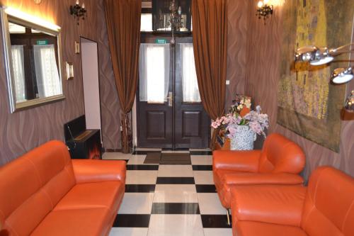 una sala de espera con sillas naranjas y una puerta en Aladin Praha, en Praga