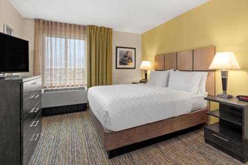 a hotel room with a bed and a television at Candlewood Suites - Fairbanks by IHG in Fairbanks