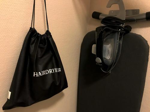 a black bag hanging on a wall with a phone at Best Western Hotel Savoy in Karlstad