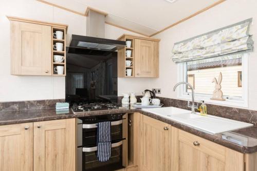 una cucina con fornelli e lavello di Thumper Lodge - Luxury lodge with Hot Tub a South Cerney