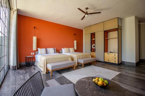 a hotel room with two beds and a table at Antelar Casa Destino in Mérida