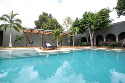 a swimming pool with a chair next to a house at Antelar Casa Destino in Mérida