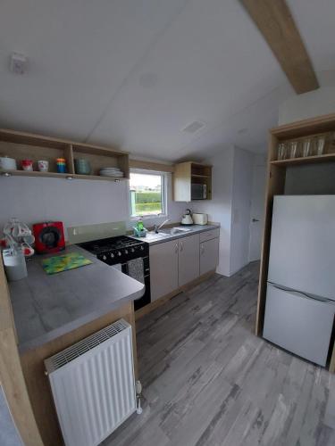 a kitchen with a white refrigerator and a stove at Woofles Luxury Caravan at Knaresborough Lido in Knaresborough