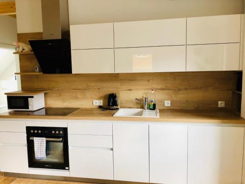 a kitchen with white cabinets and a sink at Zimmer/Wohnung Judenburg in Judenburg