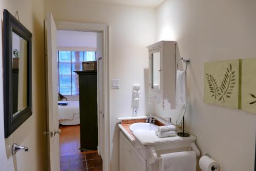 Baño blanco con lavabo y espejo en Les Immeubles Charlevoix - Le Perchoir 1019, en Quebec