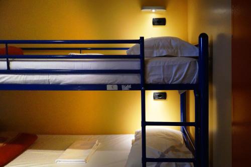 two bunk beds in a room with a yellow wall at Hi! Ostello Milano in Milan
