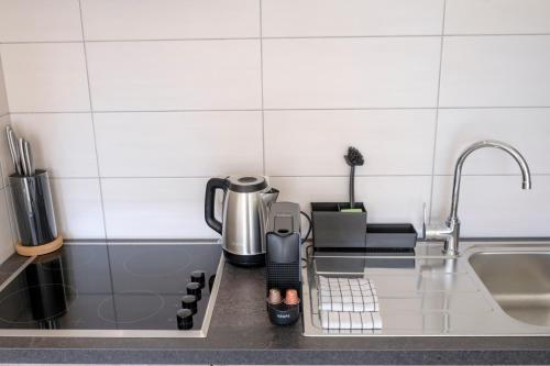 a kitchen counter with a coffee pot and a sink at Nice studios fully equipped near SHAPE area in Mons