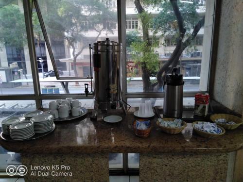 a counter with plates and cups and a blender at Hotel Atlântico Avenida in Rio de Janeiro