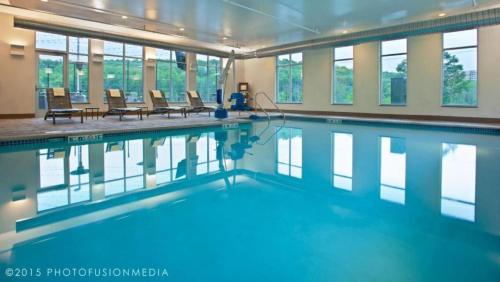 a swimming pool with blue water in a building at Hyatt Place at The Hollywood Casino Pittsburgh South in Washington