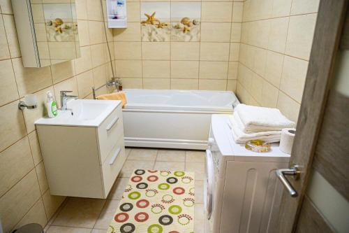 ein kleines Bad mit einer Badewanne und einem Waschbecken in der Unterkunft Aparthotel Riana in Floreşti
