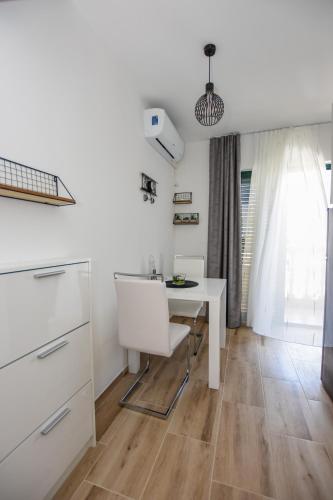 a kitchen with a white table and chairs at Apartmani Plazibat in Mandre