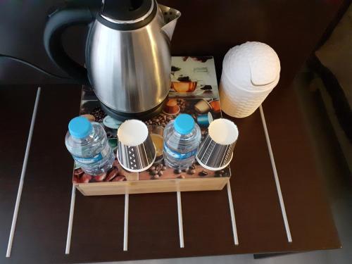 a tea pot and bottles of water on a table at Citadel Hôtel in Calais