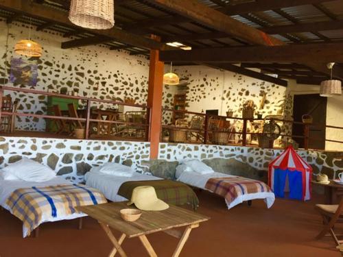 una habitación con dos camas y una mesa en Dragos del Mar , Espacio Natural, en La Orotava