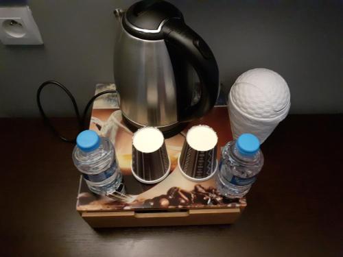 a tea kettle and some bottles of water andocolates at Citadel Hôtel in Calais