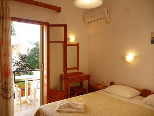 a bedroom with a bed and a mirror and a window at Giannis in Agios Georgios Pagon