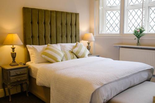 a bedroom with a large bed with a large headboard at Prince of Wales - Townhouse in London