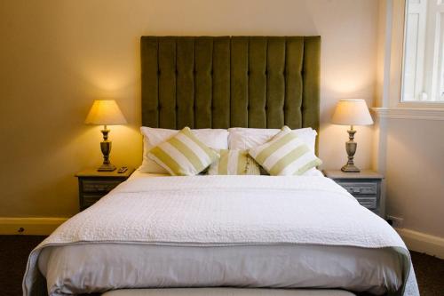 a bedroom with a large bed with two lamps at Prince of Wales - Townhouse in London