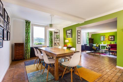 una sala da pranzo con pareti verdi e tavolo e sedie di La Maison du vigneron - Gîte de charme - 4 étoiles a Pouilly-sur-Meuse