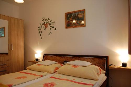 1 Schlafzimmer mit 2 Betten und 2 Leuchten an der Wand in der Unterkunft Apartment in Heviz/Balaton 18892 in Hévíz