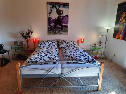 a bed in a room with a painting on the wall at Novohradské hory - pronájem na samotě u lesa in Benešov nad Černou
