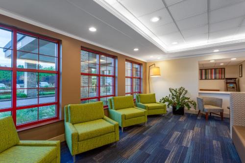 a waiting room with green chairs and windows at Holiday Inn Express Hotel & Suites Philadelphia - King of Prussia by IHG in King of Prussia
