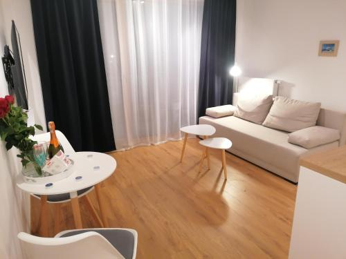 a living room with a white couch and a table at Blue Zet Apartament in Sarbinowo