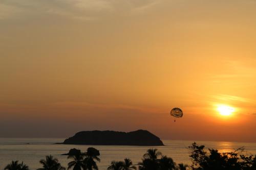 a kite flying over the ocean at sunset at Hotel San Bada Resort & Spa in Manuel Antonio