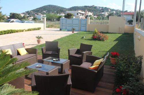 a patio with chairs and tables in a yard at Peri's Hotel in Artemida