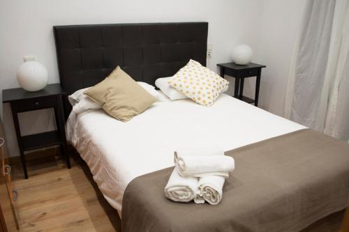 a bedroom with two beds with towels and shoes at Apartamenticos Boggiero IV in Zaragoza
