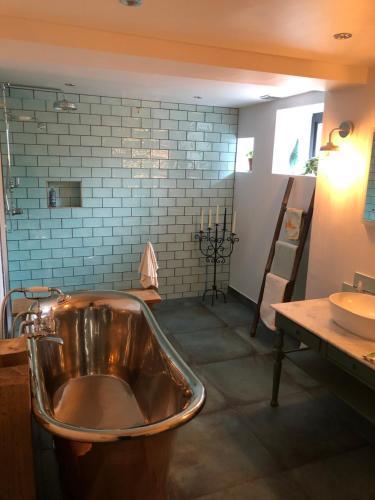 a bathroom with a copper tub and a sink at Chorlton Garden Rooms. Relax, work, stay and play. in Manchester