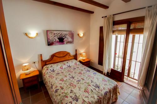 - une chambre avec un lit et 2 tables avec des lampes dans l'établissement Finca Pere - panoramic hillside holiday house in Benissa, à Teulada