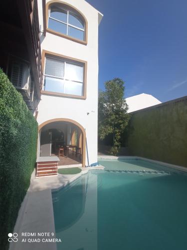 a house with a swimming pool in front of it at Palmas de Chahue in Santa Cruz Huatulco