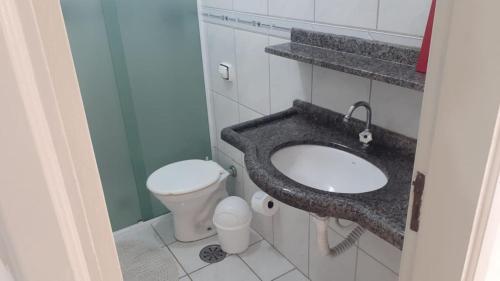 ein Bad mit einem Waschbecken und einem WC in der Unterkunft Apartamento frente a praia in Peruíbe