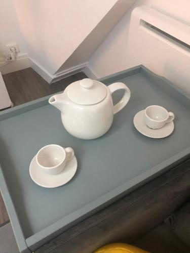 a tea pot and two saucers on a counter at ★Le Petit Cosy Vincennes★ in Vincennes