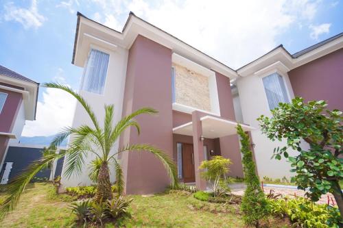a home with palm trees in front of it at Marseillia Hills in Puncak