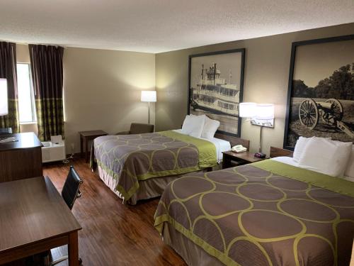 a hotel room with two beds and a desk at Super 8 by Wyndham Hernando in Hernando