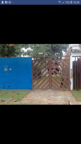 un cancello in legno in un cortile con una recinzione blu di Boracéia Beach a São Sebastião