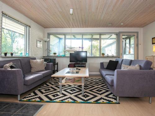 een woonkamer met 2 banken en een tv bij 7 person holiday home in Knebel in Knebel