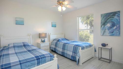 een slaapkamer met 2 bedden en een plafondventilator bij !NEW! Villa Surfside in Cape Coral