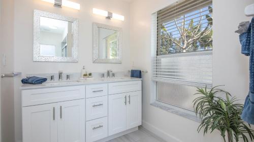 een witte badkamer met 2 wastafels en een raam bij !NEW! Villa Surfside in Cape Coral