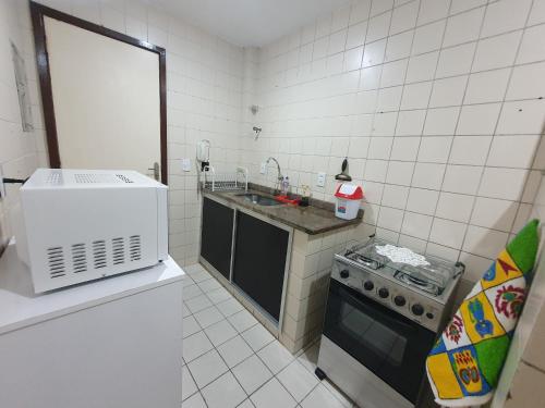 a small kitchen with a sink and a stove at Cabo Frio - Residence in Cabo Frio