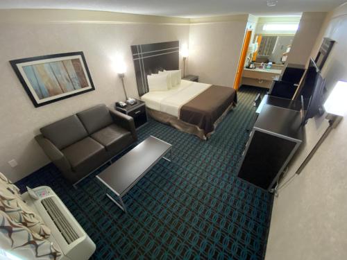a hotel room with a bed and a couch at Deluxe Inn - Fayetteville I-95 in Fayetteville